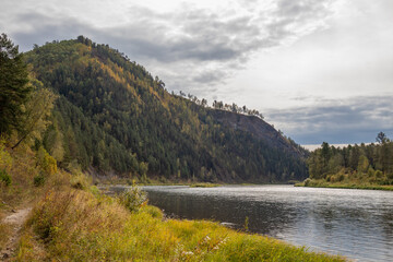 Autumn landscape. A winding river flows out of a mountainous area.