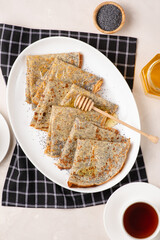 Thin crepes with poppy seeds.