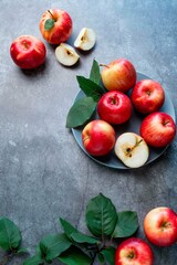 Fresh red apples with green leaves on a black background. Fruits. Top view, copy space.