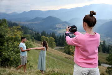 Professional photographer taking picture of couple in mountains