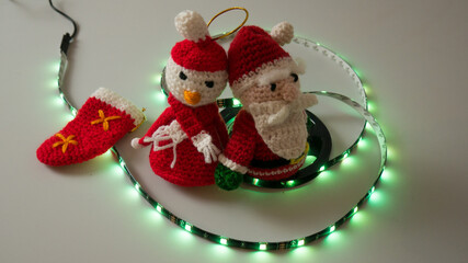 crochet christmas snowman on white background with usb led lights on the scroll, flashing and static red, blue, green, yellow, synonymous with happy and warm christmas with children and loved ones