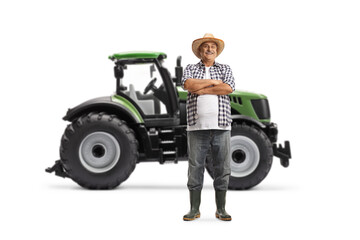 Full length portrait of a farmer standing in front of a green tractor