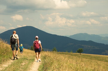 Family walks along a mountain road in the Carpathians.