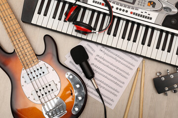 Set of different musical instruments and microphone on wooden background, flat lay