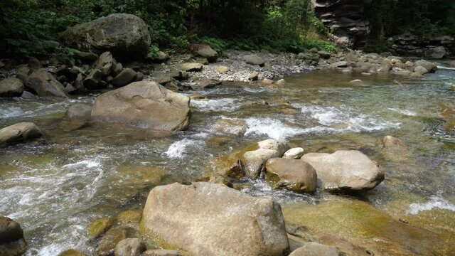 Clean crystalline waters overcoming rocky bottom in the Carpathians in summer