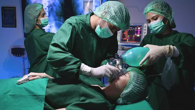 Professional surgeon doctor and team in uniform give anesthesia and IV saline drip with examining fingertip pulse of young woman treatment patient before plastic surgery in operating room at hospital.