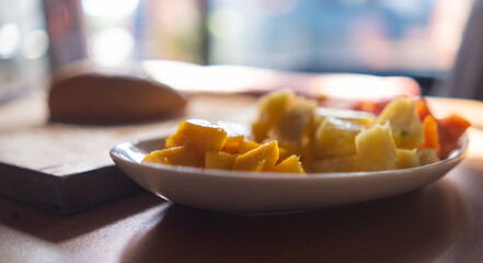 Plate of sliced fruit on table with blurry and bright background