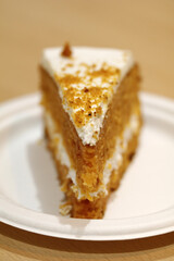 porción de tarta de bizcocho de zanahoria con nata montada y trocitos de almendra