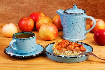 Homemade pie with apples, raisins and cinnamon on wooden table.
