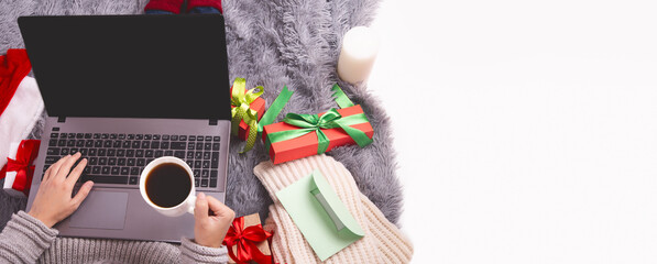 Concept black Friday, cyber monday sale, online shopping, ordering gifts online. Beautiful gift box next to laptop keyboard. Female buyer makes order on laptop computer, copy space on screen.