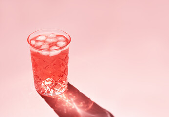 Beautiful crystal glass casts long shadow from sunlight on pink background. Minimal creative...