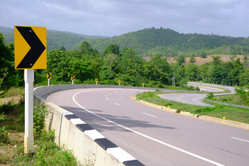 Driving safely on the road with warning signs on the way, dangerous curves, drive carefully on highways and country roads.