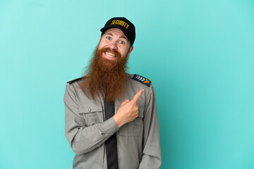 Redhead security man isolated on white background pointing to the side to present a product