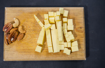 Fresh diced cheese and walnuts on a cutting board