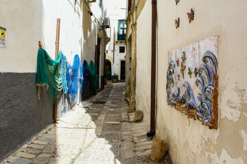 Drying fish nets in Mazara del Vallo narrow street on a summer day, Trapani, Sicily, Italy