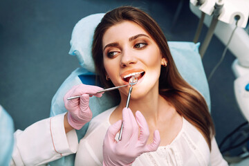 Overview of dental caries prevention. Dentist examining patient's teeth in modern clinic. Healthy teeth and medicine concept.