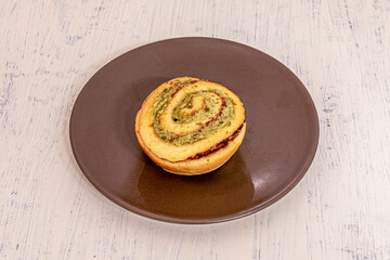 Savory cinnamon roll stuffed with Italian pesto sauce with pistachios and basil