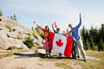 Fotobehang Happy Canada Day. Family with large Canadian flag celebration in mountains. © AS Photo Family