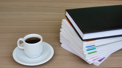 A stack of books and a cup of coffee on the table. Space for text.