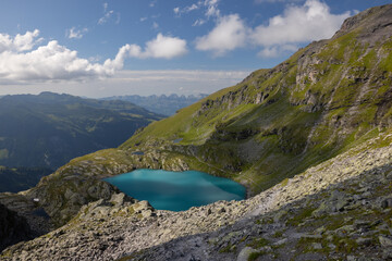 Naklejka na ściany i meble A wonderful view to the horizon at a beautiful sunset in the alps of Switzerland by an alpine lake called Schottensee. These colors by the sunset are just amazing. Epic clear blue water.