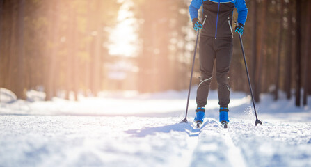 Banner cross-country skiing in winter on snowy track, sunset background