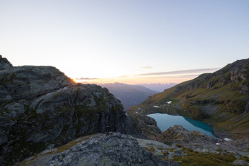 Fototapeta na wymiar A wonderful view to the horizon at a beautiful sunset in the alps of Switzerland by an alpine lake called Schottensee. These colors by the sunset are just amazing. Epic clear blue water.