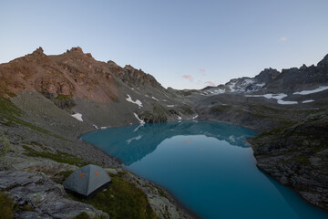 Obraz premium A wonderful view to the horizon at a beautiful sunset in the alps of Switzerland by an alpine lake called Schottensee. These colors by the sunset are just amazing. Epic clear blue water.