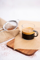 Fresh tasty espresso cup of hot coffee with cocoa powder on light background. Cup of espresso coffee, coffee concept. 