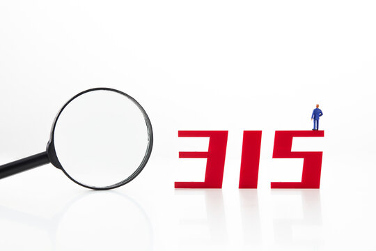 Red number 315 with a miniature figurine and magnifying glass isolated on white background