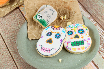 Skull-shaped buttery biscuits on brown paper and a green plate.