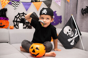 A cute five year old boy stayed at home with a bucket of pumpkin candy in a pirate costume. Ready...