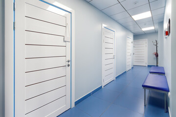 Empty corridor in modern hospital with blue benches