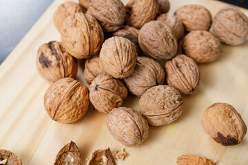 Close-up of group of whole walnuts on a wooden board. Food textures.