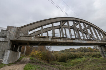 Old railway bridge over the river. Reinforced concrete bridge structure.