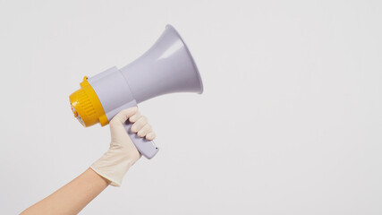 Hand is hold megaphone and wear medical glove on white background..