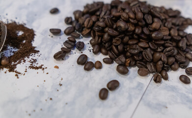 Small pile of roasted coffee beans on white surface