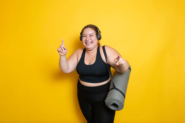 fat fitness woman laughing carrying rolled yoga mat with strap wearing sportswear