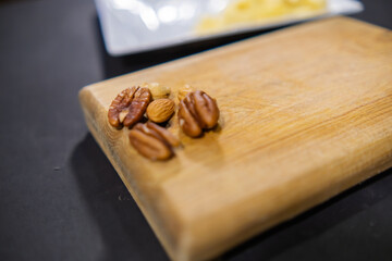 Walnuts, almonds, and Indian nuts on wooden cutting board