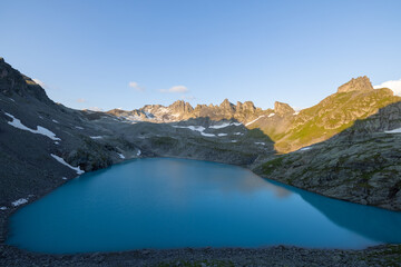 Obraz premium Wonderful morning view over an beautiful alpine lake called Wildsee in Switzerland. Amazing clear blue lake and the sun shine to the peaks of the glacier.
