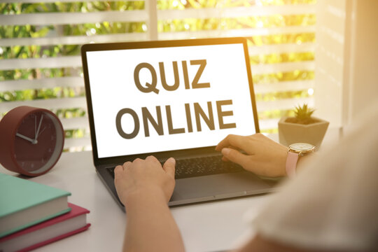 Woman Using Modern Laptop For Taking Quiz Online At Table, Closeup