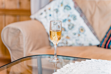 A glass of champagne on the table. Sparkling drink in a rustic interior.