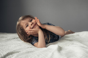 Little cute girl lying on the bed.