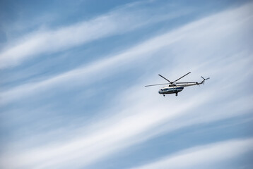 Fototapeta na wymiar Passenger helicopter against the background of a blue sky with clouds.