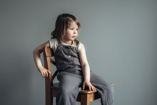 Little cute girl sitting on the chair.