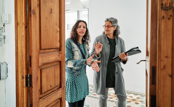 Real estate agent showing to woman while standing in rental apartment
