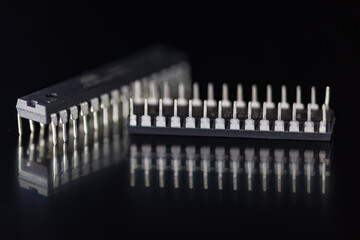 DIP microchips electronic components on dark blue mirror macro shot.