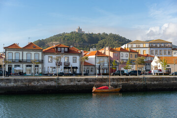 Viana do Castelo city viewed from the other side of the river with boats and Santa Luzia chruch sanctuary on the hill, in Portugal