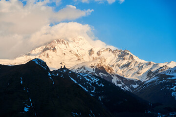 Dawn in the mountains. The sun's rays fall on the top of Mount Kazbek. An inspiring morning for the traveler
