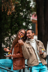 A photo of a modern man and woman enjoying the city and eating delicious fresh poffertjes