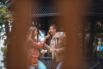 A photo of a modern man and woman enjoying the city and eating delicious fresh poffertjes